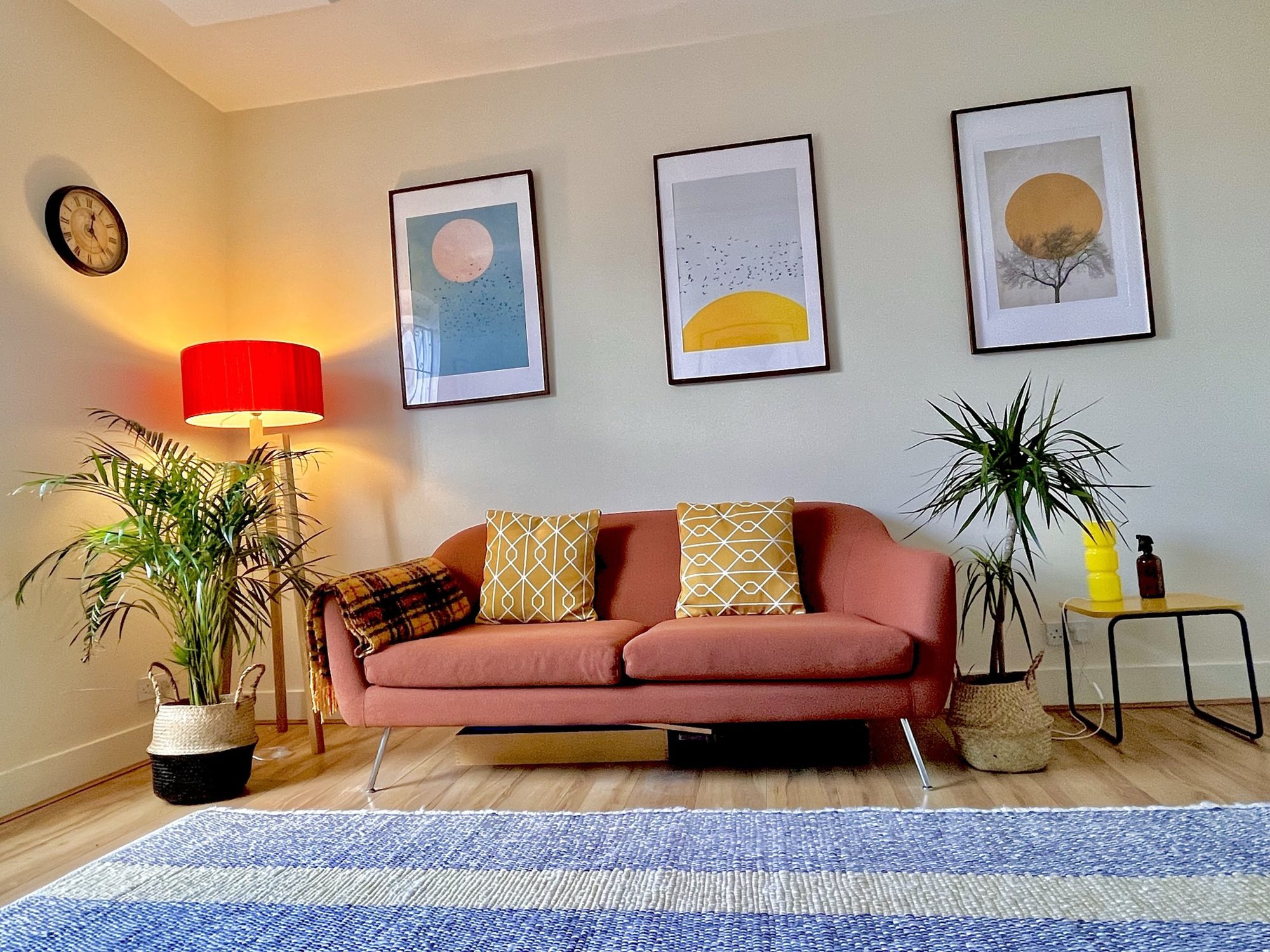 Therapy room with terracotta sofa, plants and framed prints at Hackney Therapy House