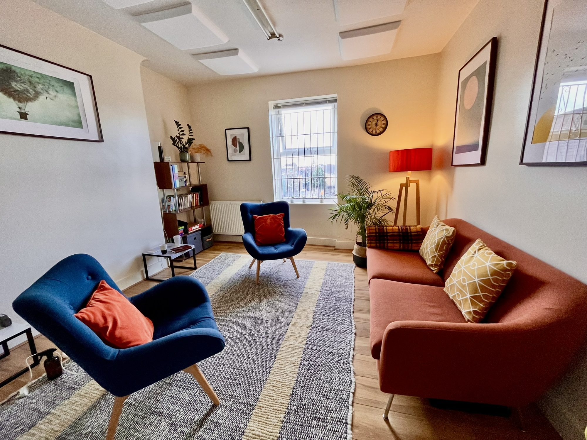 Therapy room with terracotta sofa and blue armchairs at Hackney Therapy House, Dalston